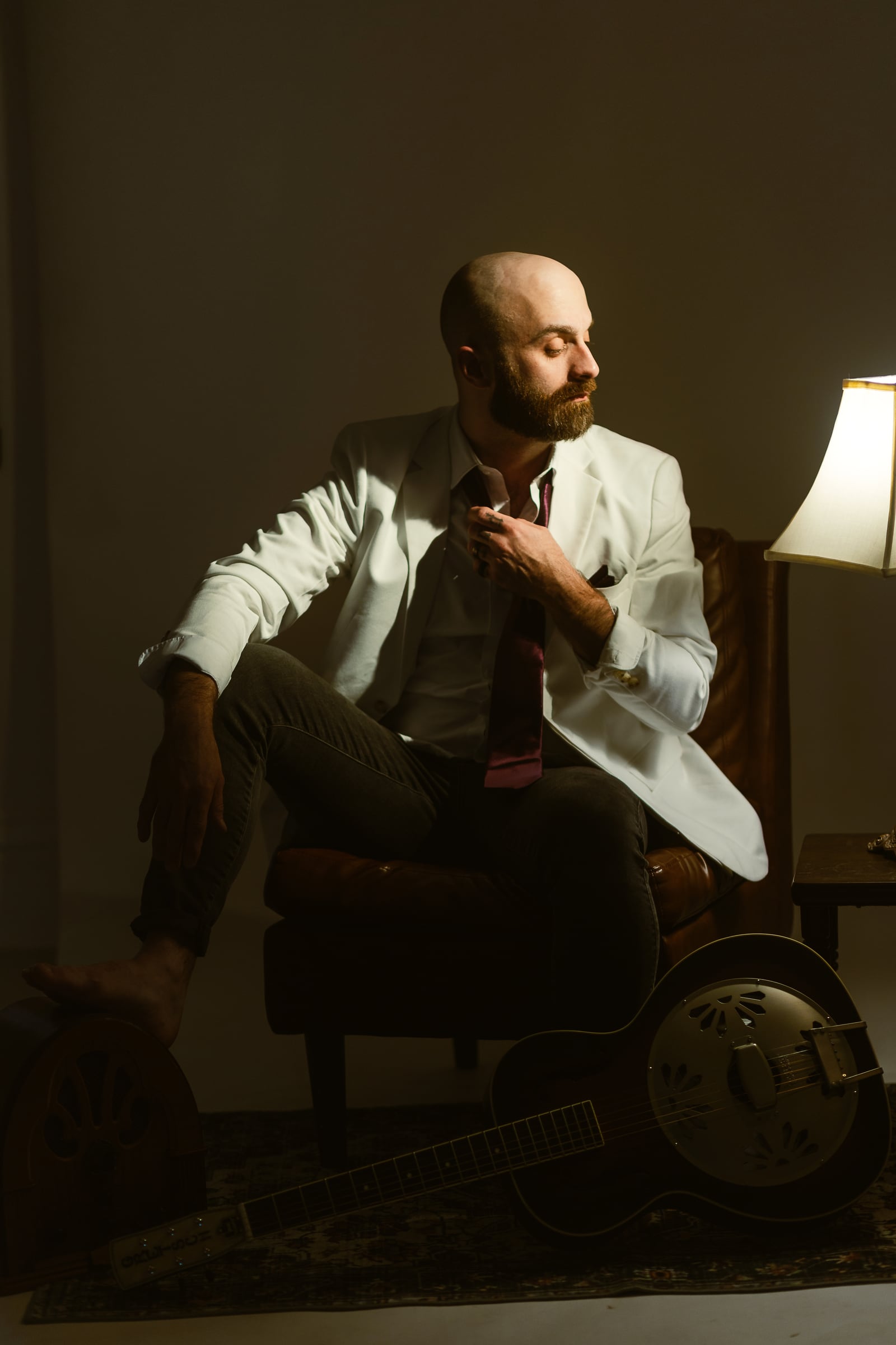 Joshua T. Hester seated with a resonator guitar